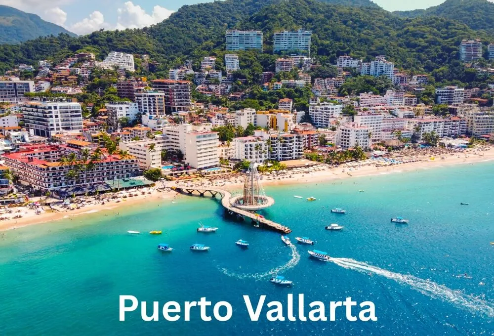 puerto-vallarta-beachfront-with-pier-boats-and-hillside-buildings-in-mexico