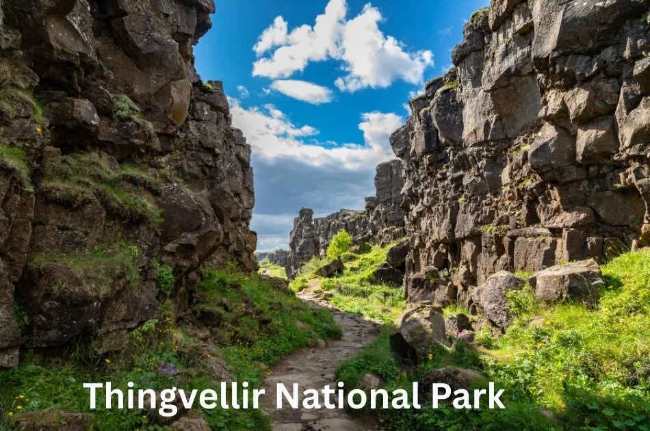 Thingvellir National Park Iceland with rocky cliffs, lush greenery, and scenic walking trail under blue sky